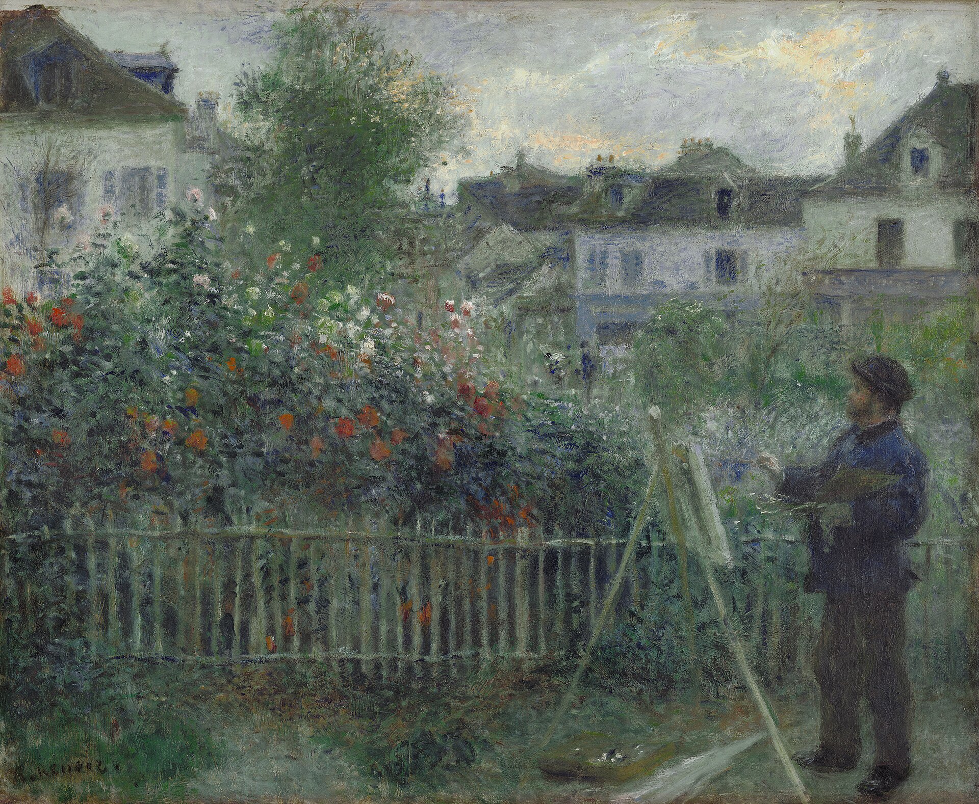 Monet standing at his easel in a garden, palette in hand, beside a fence and a bank of red and white dahlias, with houses behind